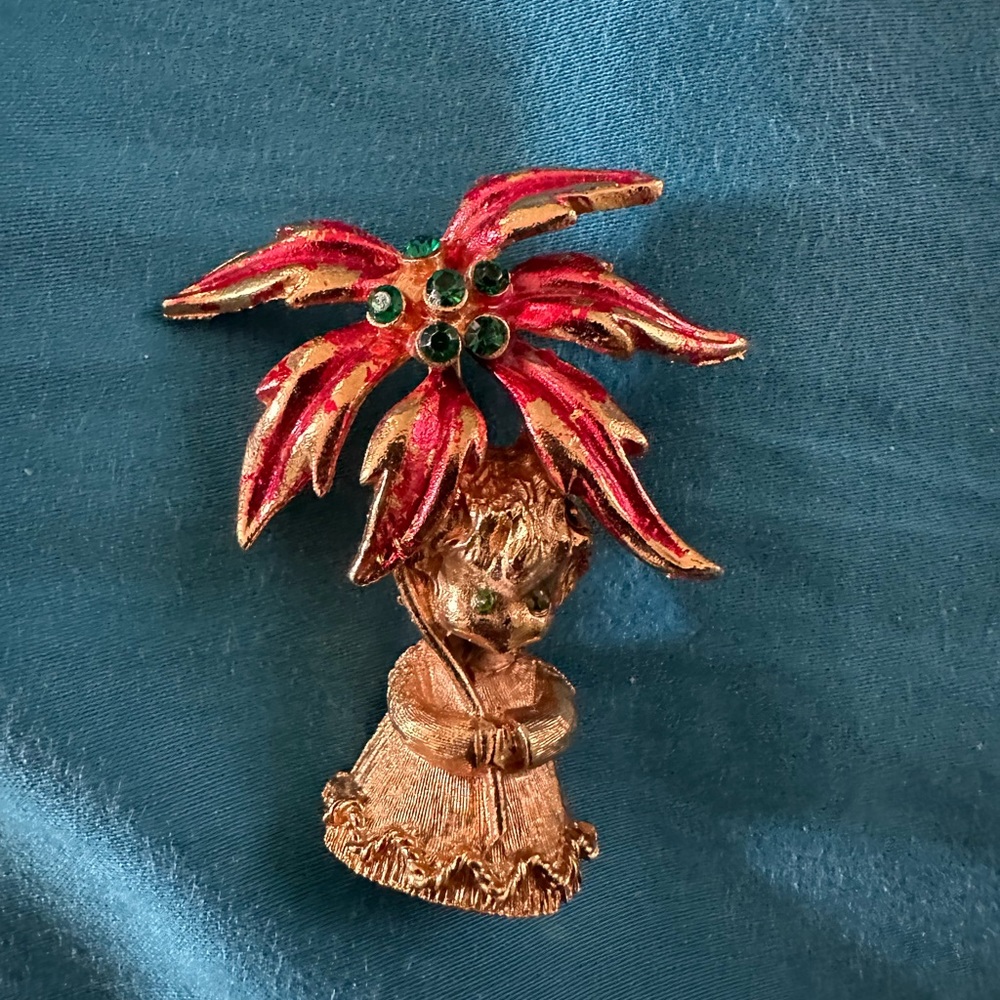 Vintage holiday pin with green crystal stones in eyes and on poinsettia